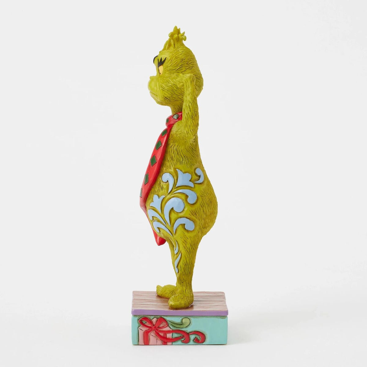 A Dr. Seuss Grinch figurine posing with his arms flexed, wearing a red and green polka-dot scarf and blue swirl patterns on his yellow-green skin, standing on a base that reads 'MERRY GRINCHAS'.