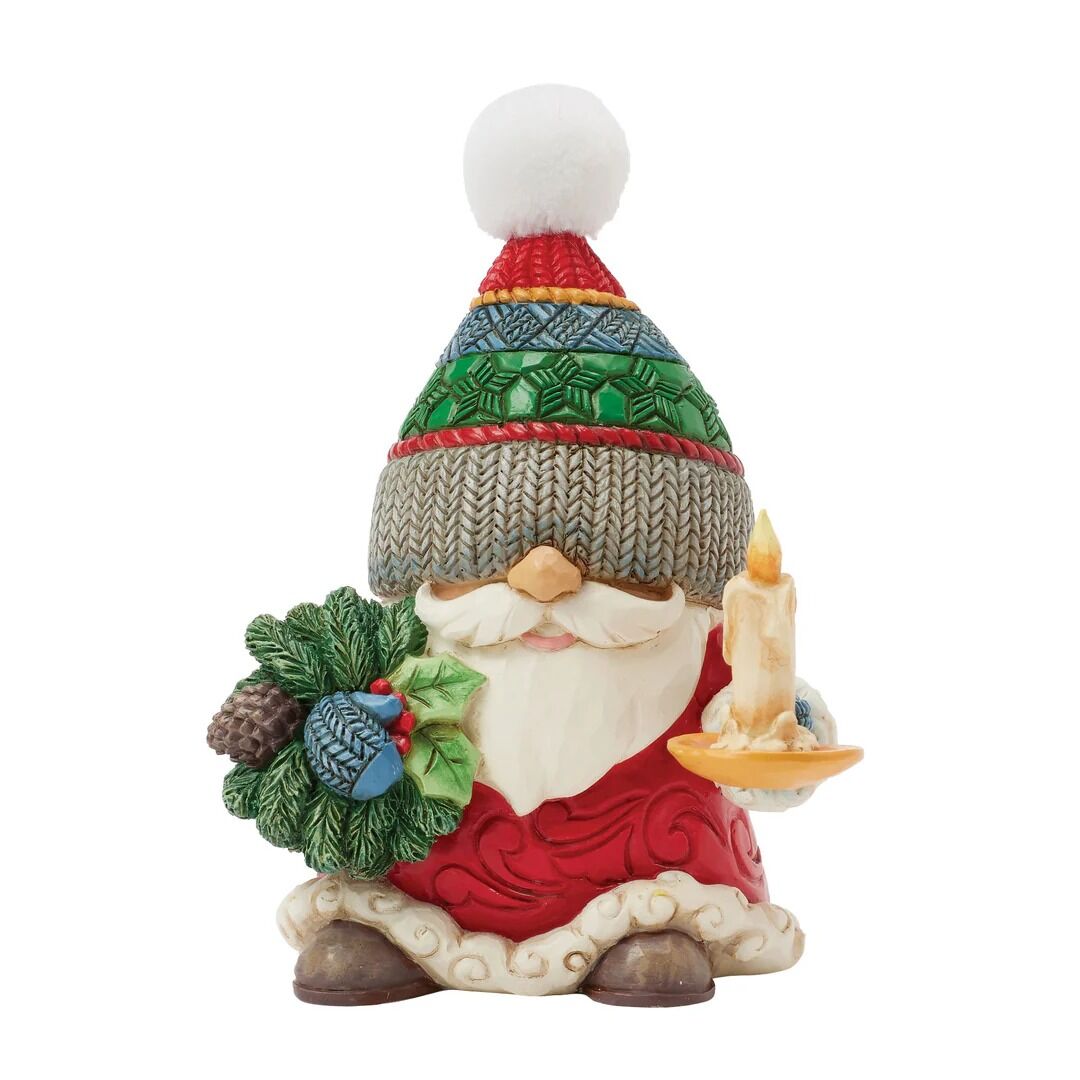 Decorative gnome figurine with a colorful hat, wreath, and candle on a white background