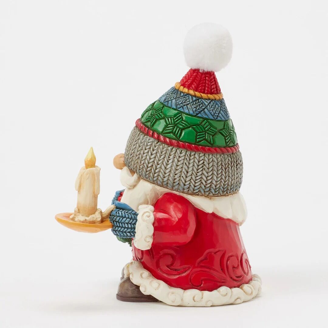 Decorative gnome figurine with a colorful hat and candle, on a white background