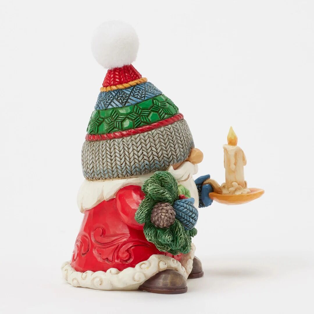 Decorative gnome figurine with a colorful hat and candle on a white background