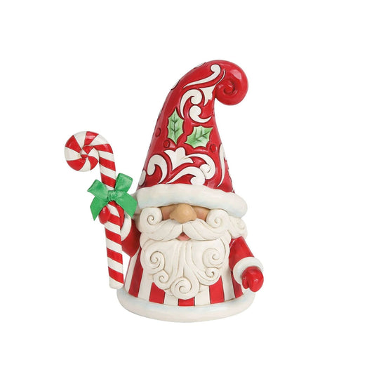 Decorative gnome figurine with red and white striped hat and candy cane on a white background