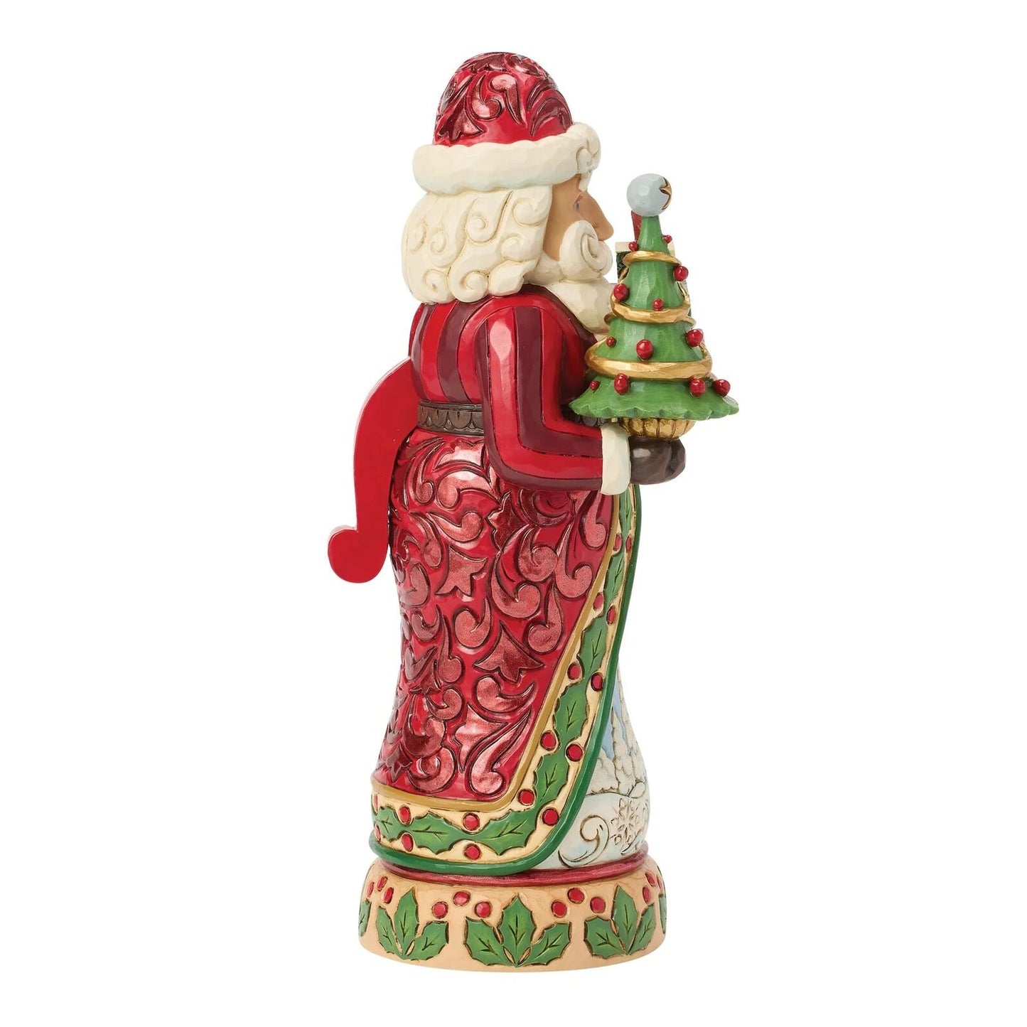 A Santa Claus figurine shown from the side, holding a small decorated Christmas tree. The figurine has a red robe with white fur trim, a red hat, white beard, and green and gold accents on the robe and tree, set against a plain white background.