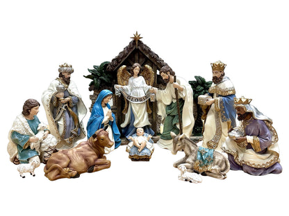 A multi-piece ceramic nativity set featuring Mary, Joseph, baby Jesus, the three wise men, an angel, a shepherd, a cow, a donkey, and a stable, displayed against a solid white background.