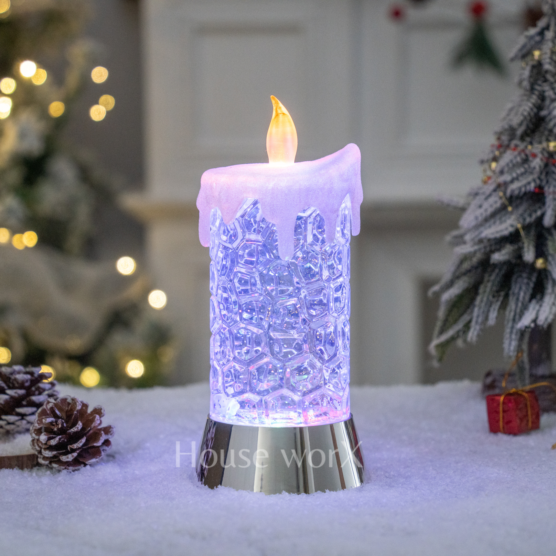 Decorative LED candle with lace design in a festive setting with Christmas trees and lights.