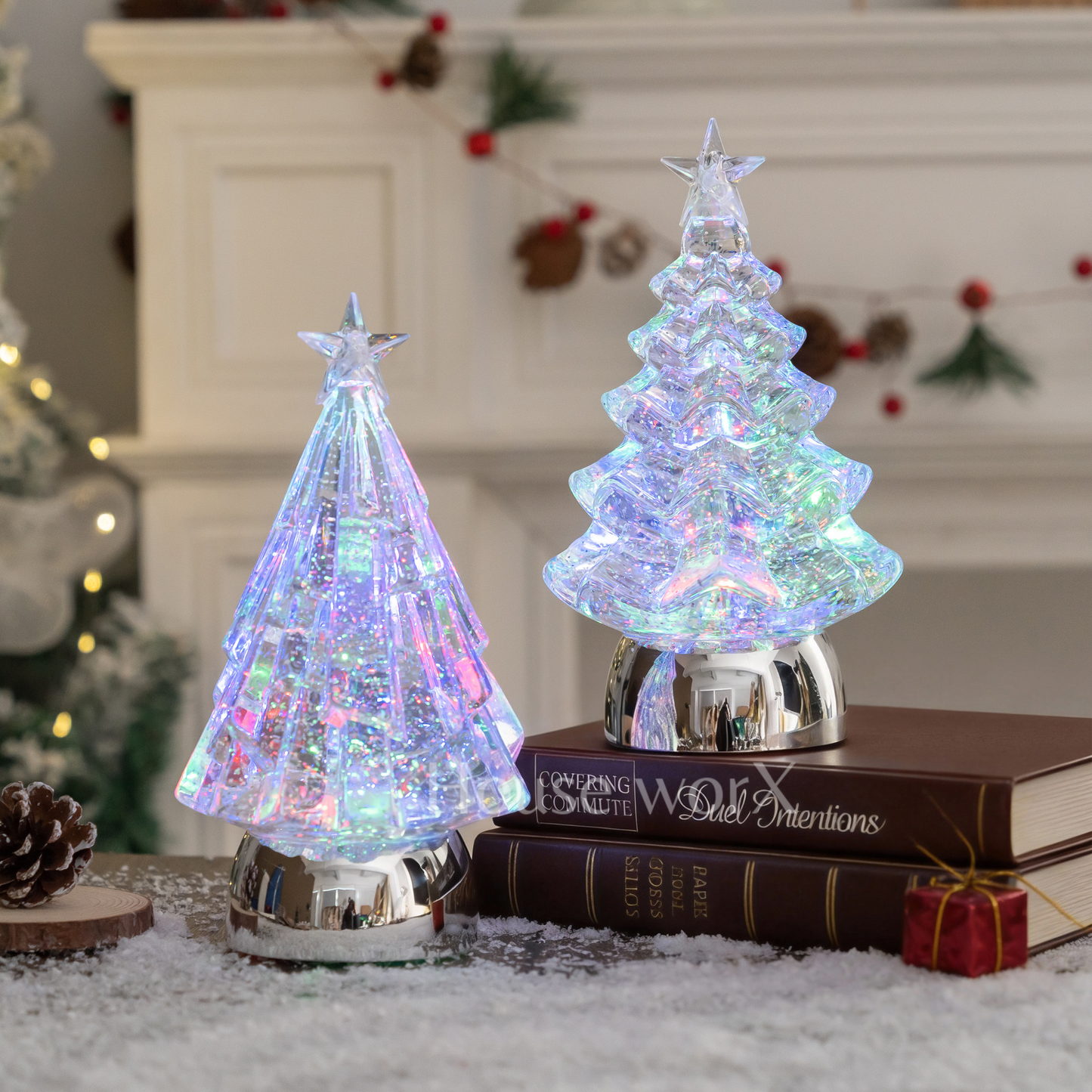 Two iridescent Christmas tree snow globe on books with a festive background.