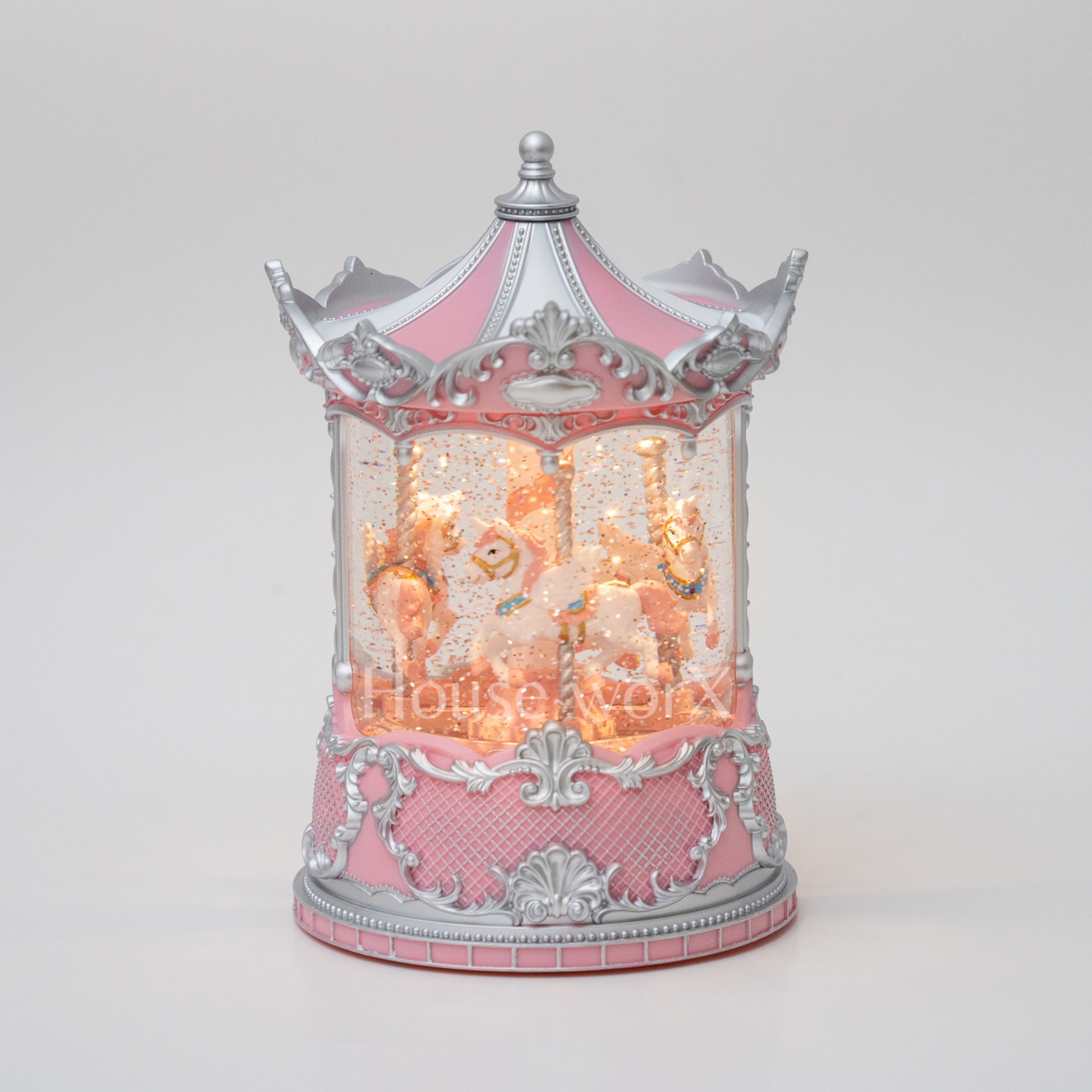 Decorative carousel with pink and silver design on a white background snow globe