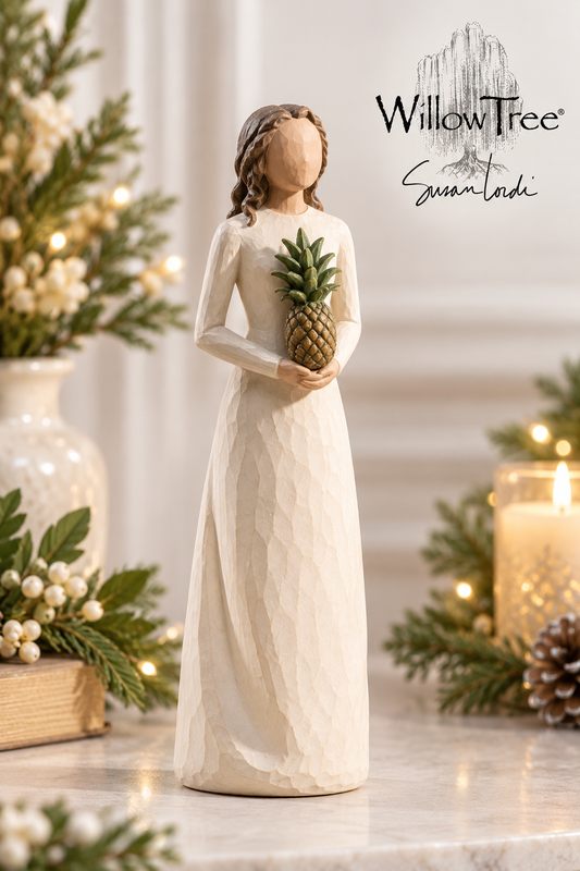 A WillowTree 'Summer Lady' figurine stands on a marble surface, holding a pineapple. The figurine is dressed in a long cream-colored gown.