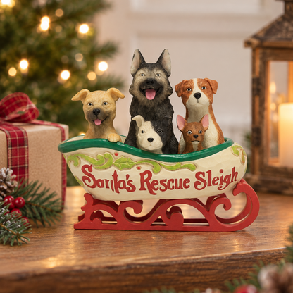 Jim Shore Heartwood Creek 'Santa's Rescue Sleigh' figurine featuring four dogs sitting in a decorated sleigh on a wooden tabletop with a Christmas tree and gift box in the background.