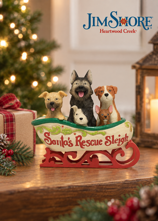 Jim Shore Heartwood Creek 'Santa's Rescue Sleigh' figurine featuring four dogs sitting in a decorated sleigh on a wooden tabletop with a Christmas tree and gift box in the background.