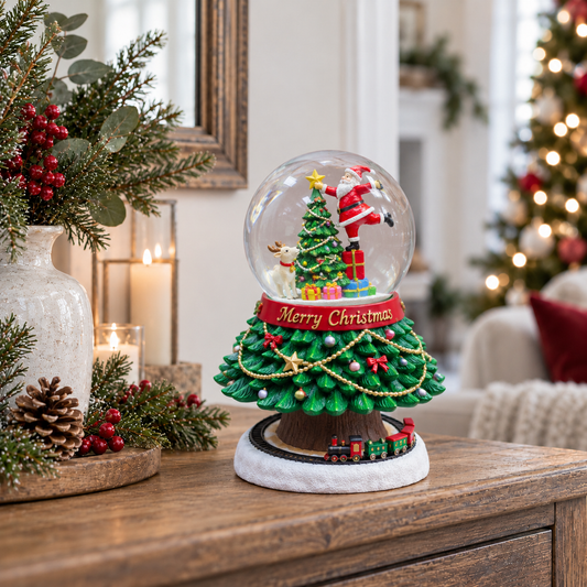 A festive Christmas snow globe decoration on a wooden table, featuring a miniature green Christmas tree, Santa Claus, a reindeer, ornaments, and a small train, with a blurred holiday home background.