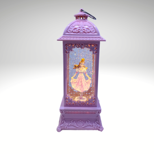 A purple decorative lantern ornament featuring a printed illustration of a princess in a pink dress inside a glittery window, with a small metal loop on top, shown against a light gray gradient background.