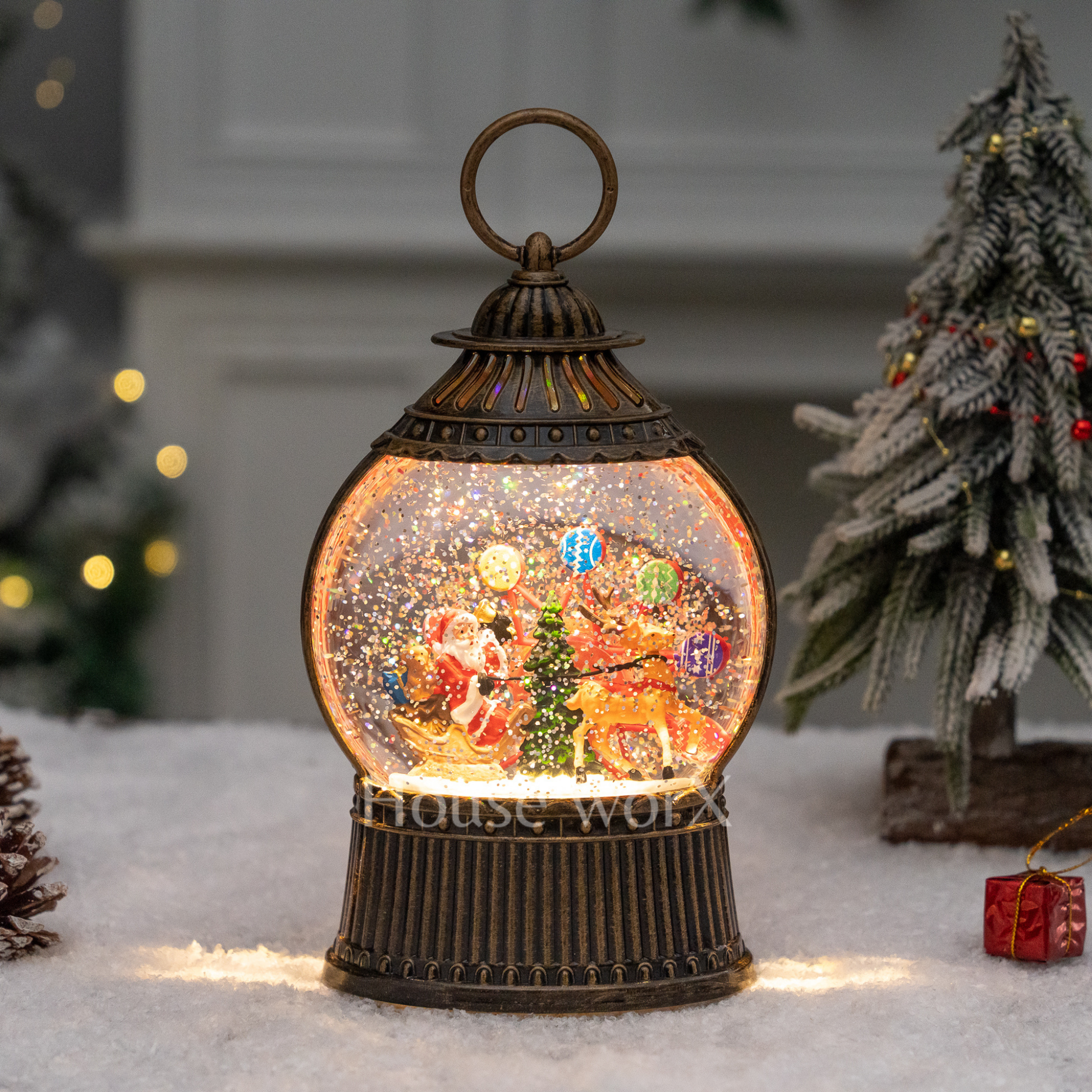 Decorative lantern with a snow globe featuring Santa Claus and reindeer on a snowy background.