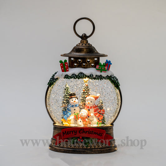 Decorative snow globe with Christmas scene inside a lantern on a gray background