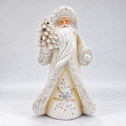A Santa Claus figurine in a textured off-white fur-trimmed coat, holding a small decorated Christmas tree, photographed against a seamless light gray studio background.