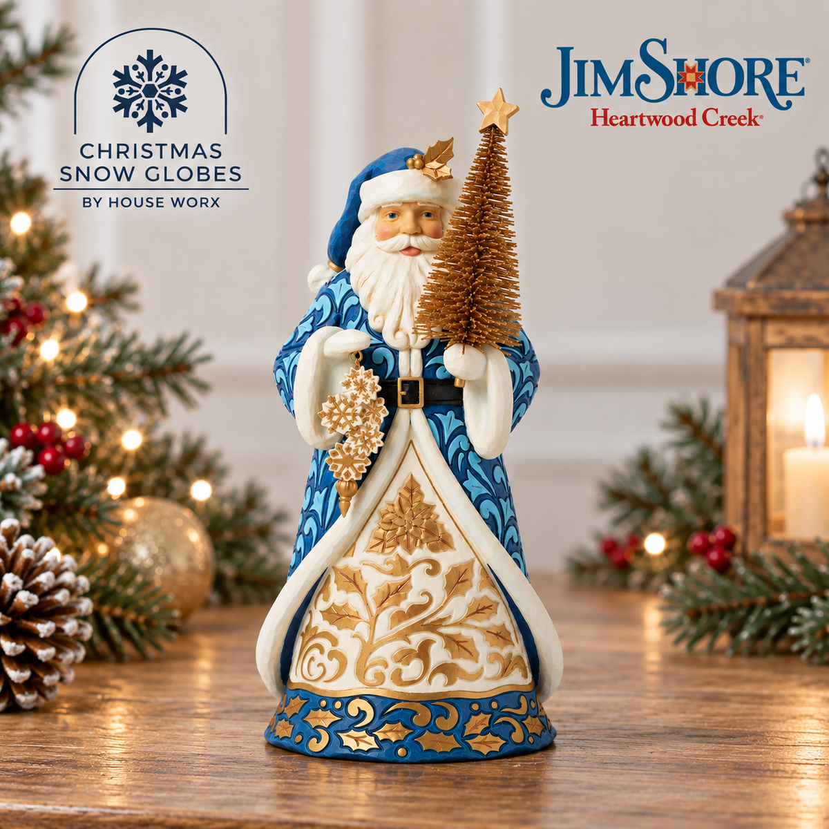 A Jim Shore 'Christmas Snow Globe' figurine of Santa Claus in a blue and white coat holding a gold Christmas tree, displayed on a wooden surface with holiday decorations in the background.