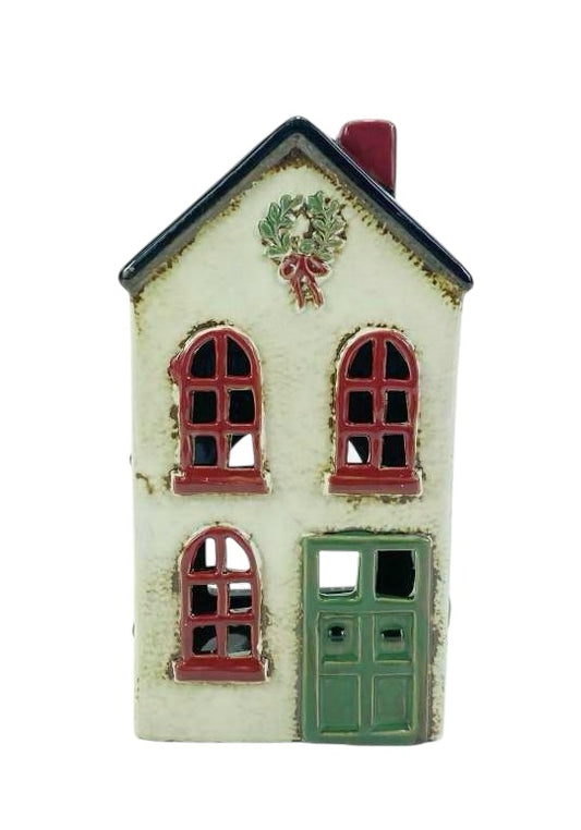 Decorative miniature house with a wreath on a white background