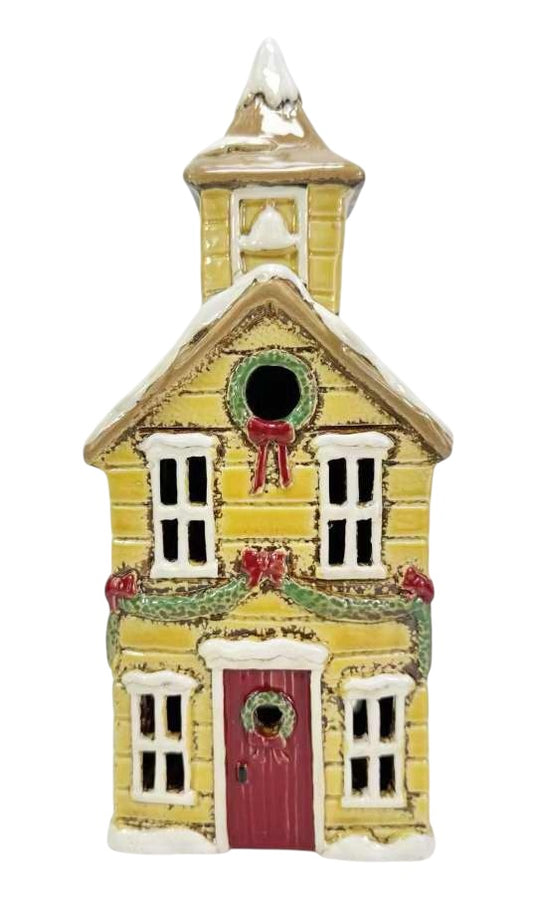 Decorative yellow house ornament with a red door on a white background