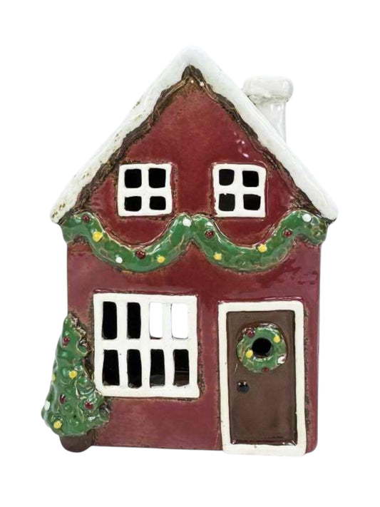 Decorative miniature house with red roof and green trim on a white background