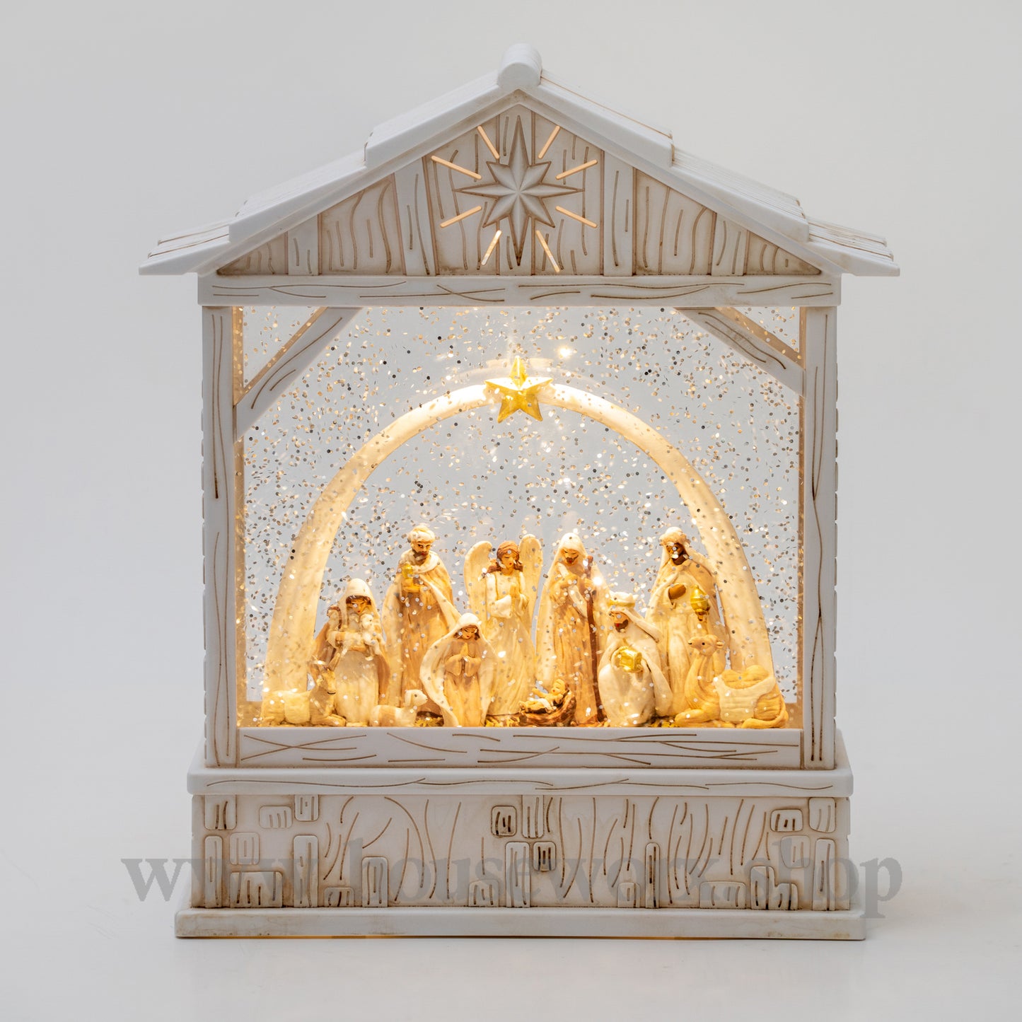 Decorative nativity scene in a wooden crèche with glowing figures on a white background. christmas snow globe classic