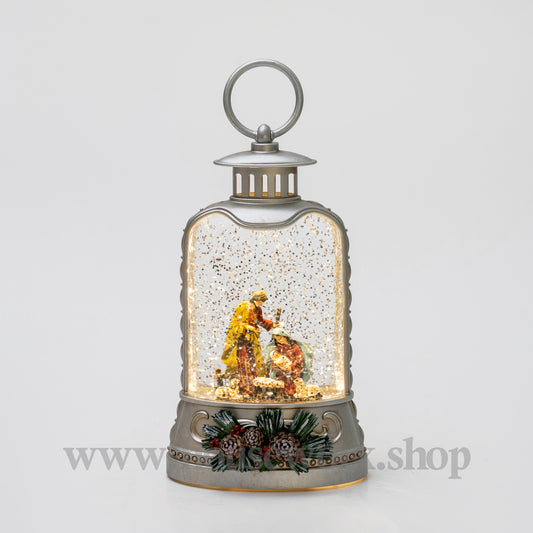 Decorative lantern with a snow globe featuring a nativity scene on a light gray background.