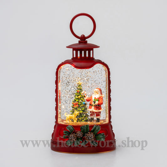 Red lantern-shaped snow globe with Santa Claus and a Christmas tree inside on a light gray background.