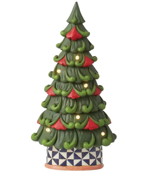 A decorative Christmas tree figurine with layered green branches, red ornaments, warm white string lights, and a patterned blue-and-white base on a plain white background.