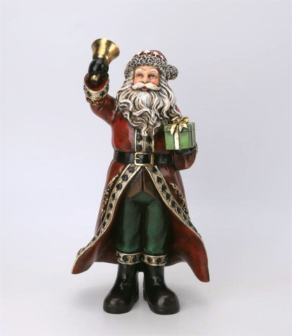 A Santa Claus figurine holding a gold bell and a green gift box, dressed in a red coat with gold trim, green pants, and black boots, set against a plain light gray background.