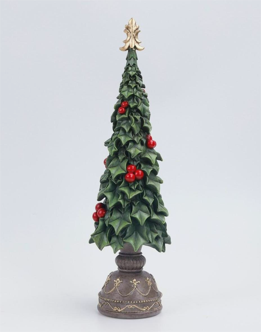 A decorative miniature Christmas tree with green holly leaves, red berries, and a gold star topper, mounted on an ornate dark pedestal base against a light gray background.