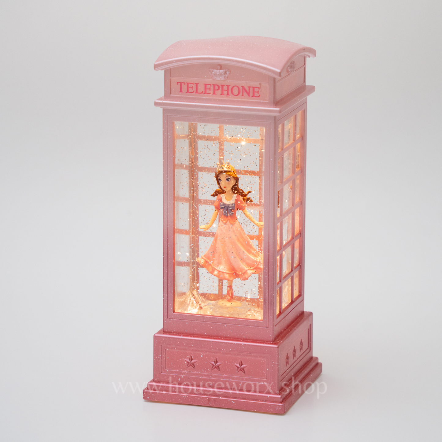 Pink telephone booth with a figurine inside on a white background