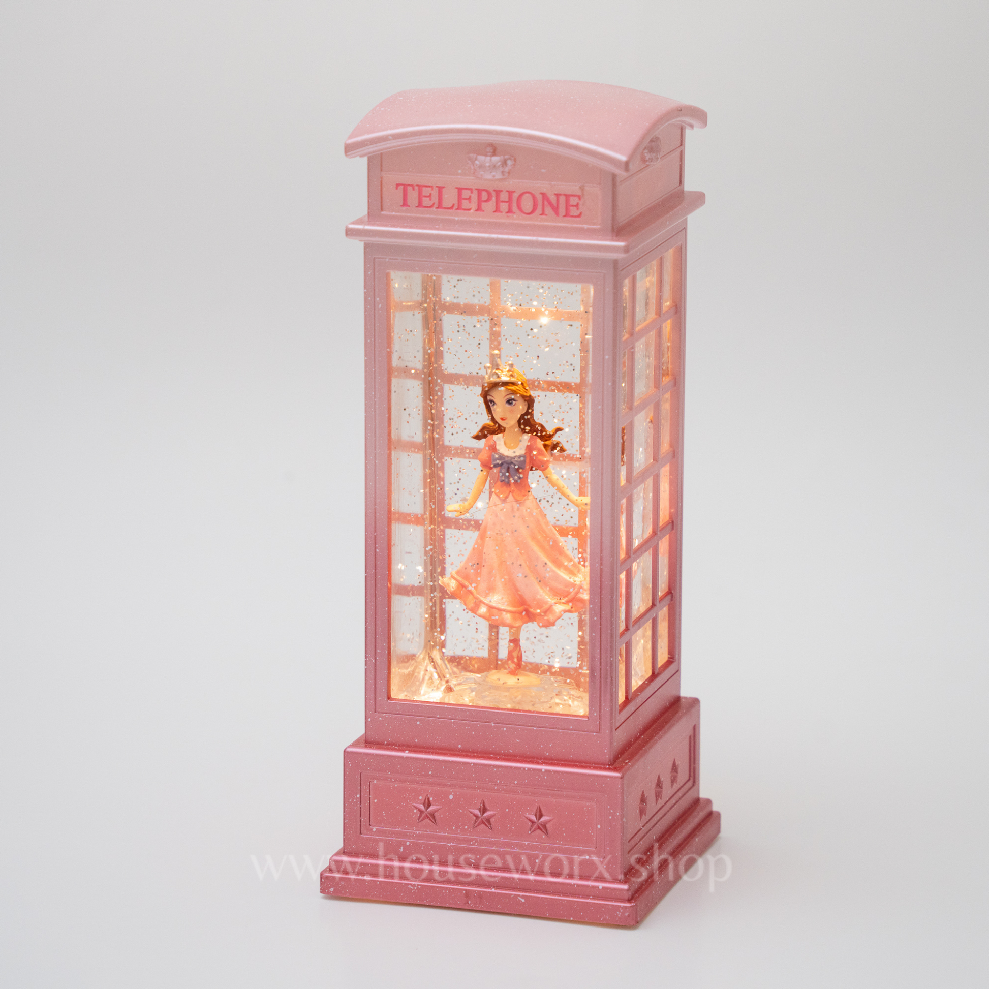 Pink telephone booth with a figurine inside on a white background