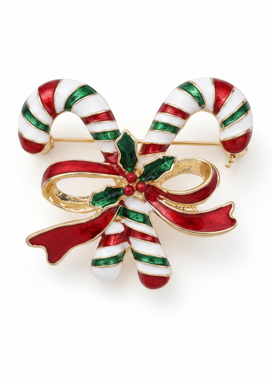 A Christmas-themed candy cane brooch featuring two striped candy canes tied with a red and green bow, accented with gold-tone metal and small red berries on a white background.