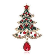 Christmas tree-shaped brooch with red gem on a white background