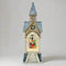 Decorative clock tower with a lit scene inside on a white background