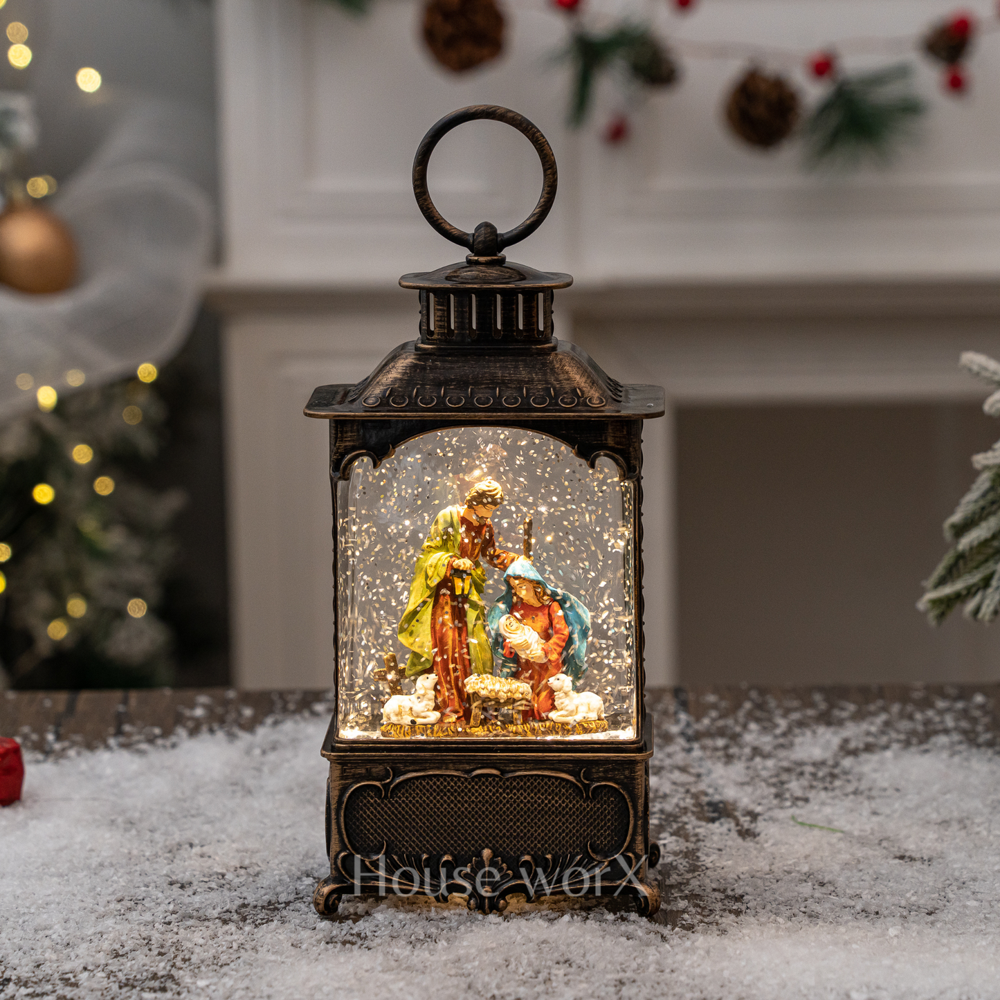 Decorative lantern with a nativity scene inside, surrounded by Christmas decorations.