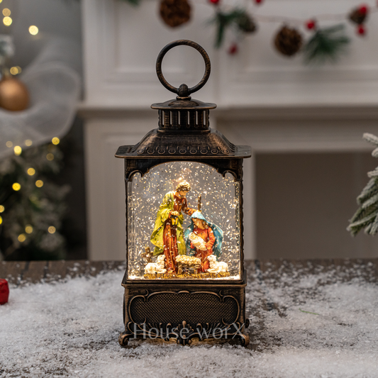 Decorative lantern with a nativity scene inside, surrounded by Christmas decorations.