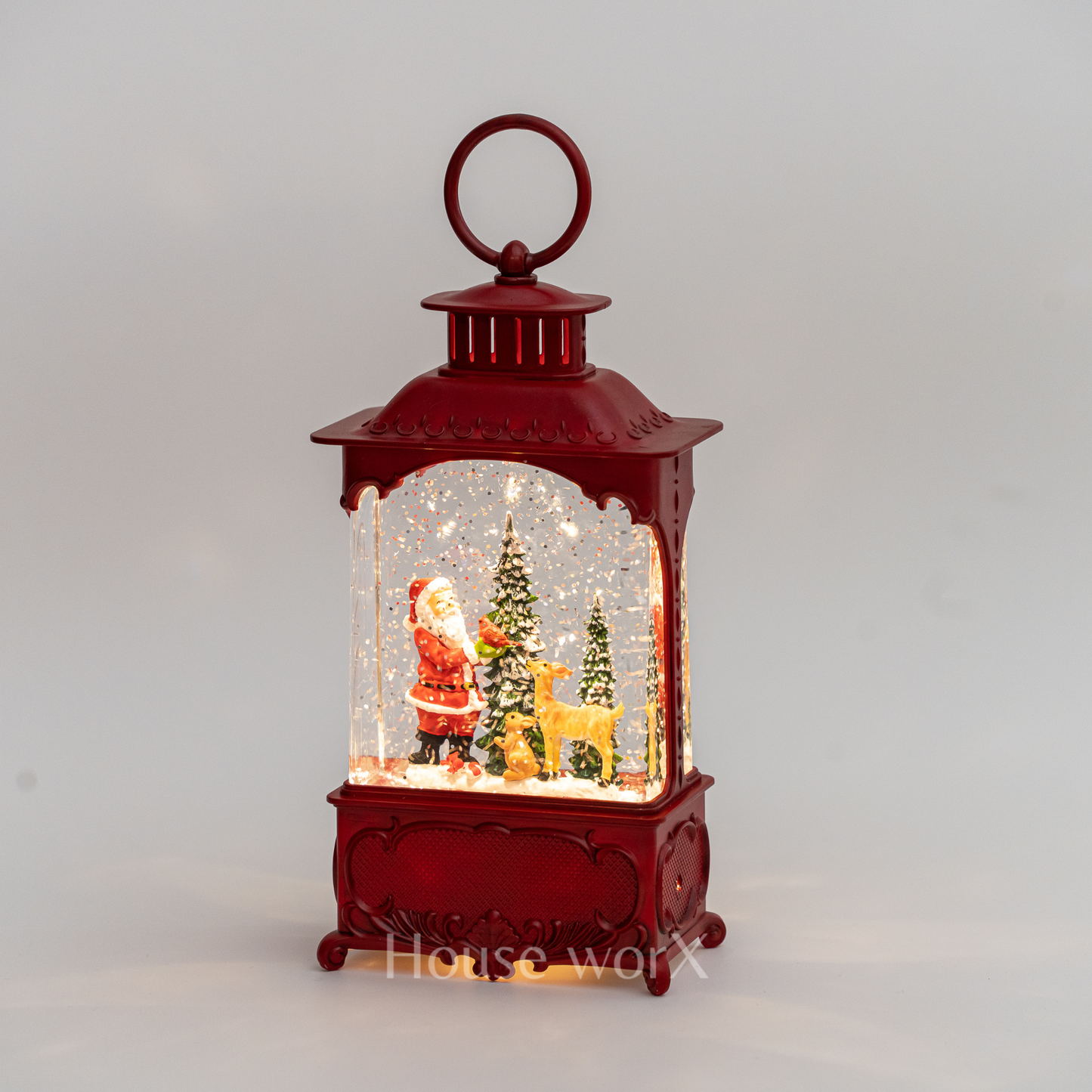 Red lantern-shaped snow globe with Santa Claus and reindeer inside on a gray background