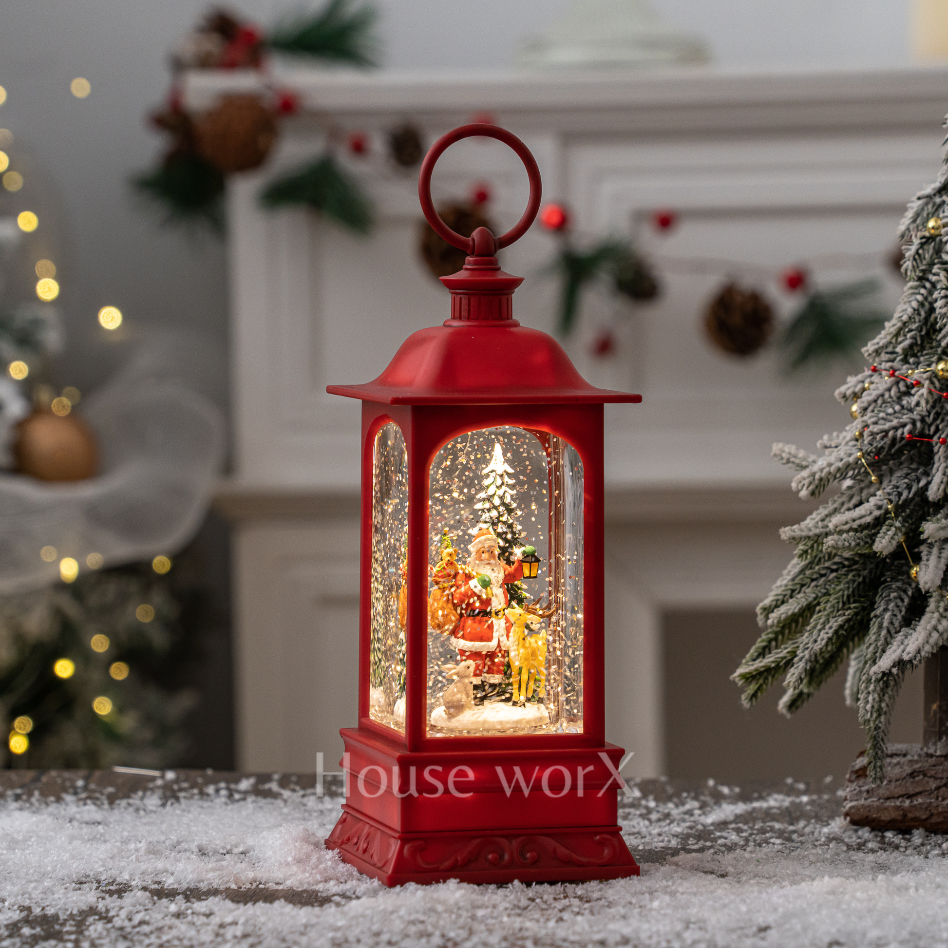 Decorative red lantern with a Christmas scene inside, placed on a snowy surface with a festive background.