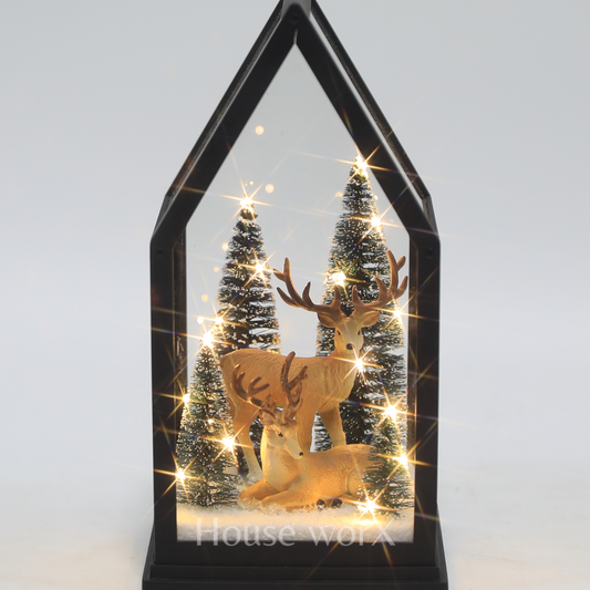 Decorative display with deer and trees inside a black frame on a white background