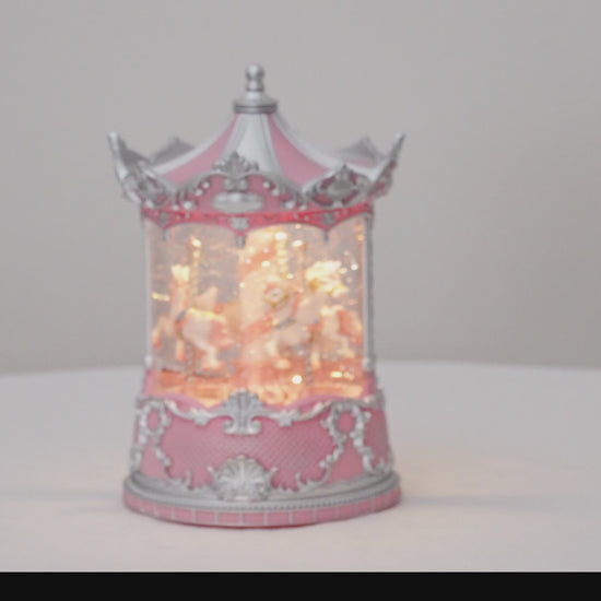 Decorative carousel with pink and silver design on a white background snow globe vdeo