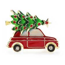 Red car brooch with a Christmas tree on top against a white background