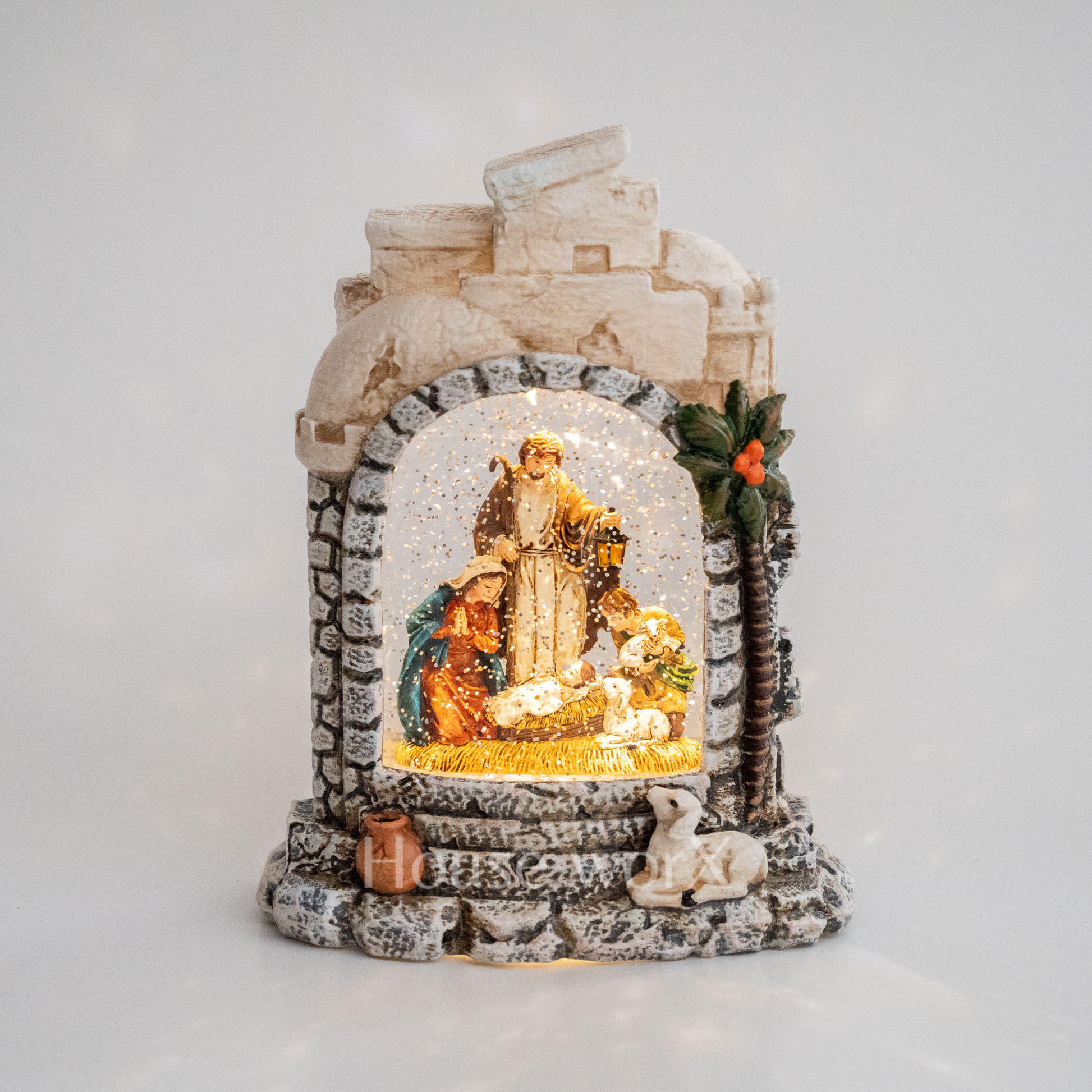 Decorative nativity scene in a stone arch with a white background snow globe