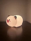 White ceramic piggy bank with a red nose on a dark surface