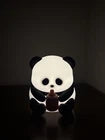 Panda-shaped night light on a dark surface