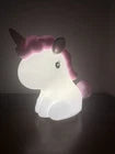 Unicorn-shaped night light with a soft glow on a dark background