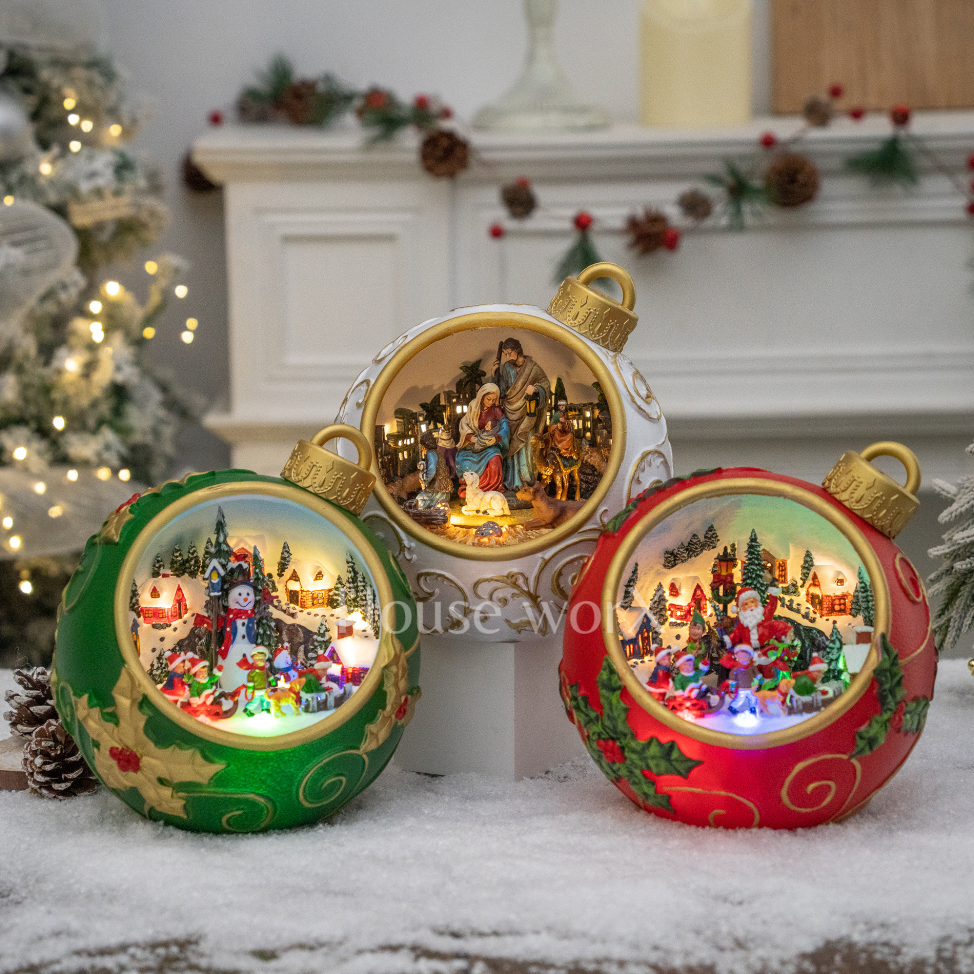 Decorative Christmas ornaments with lit scenes on a snowy surface.
