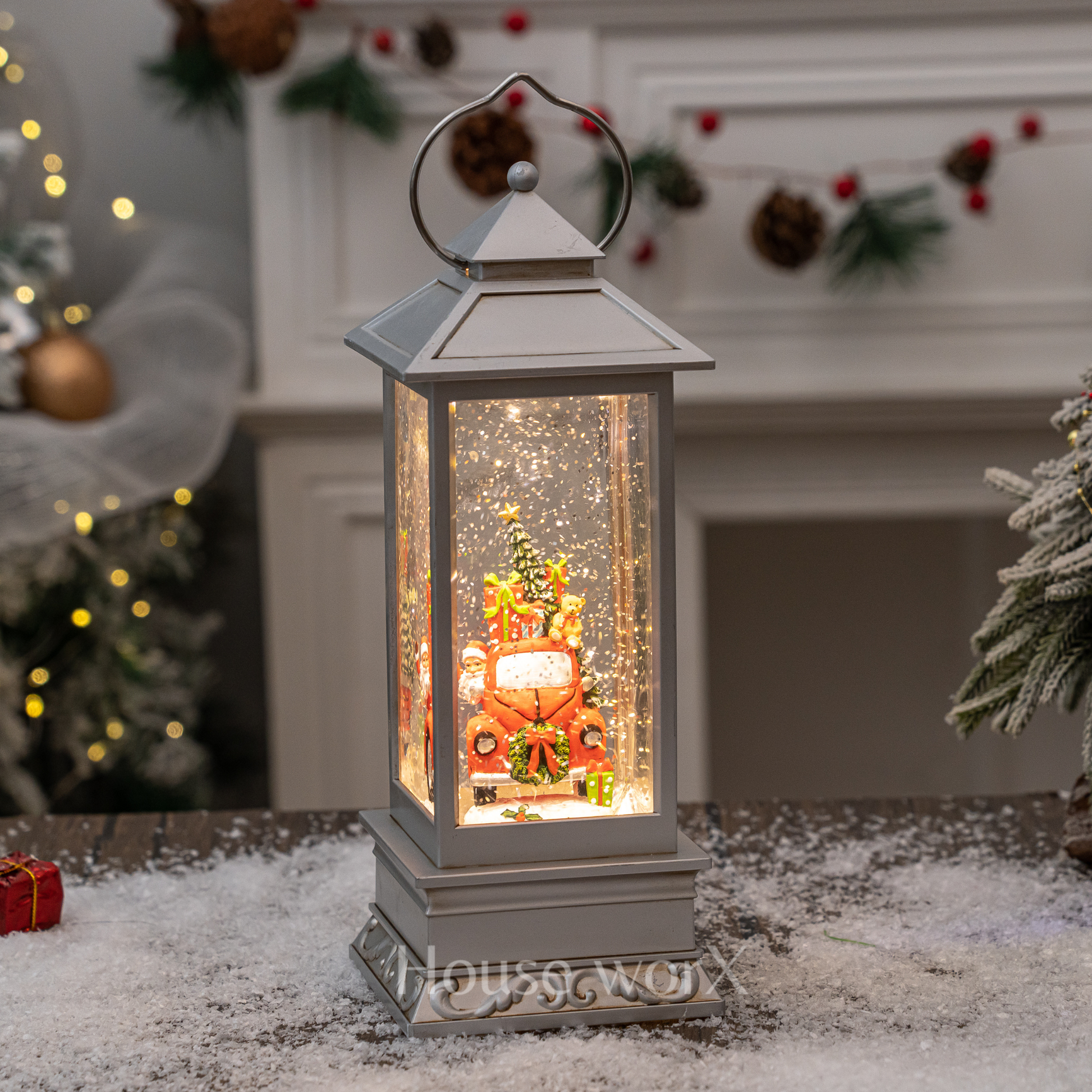 Decorative lantern with Christmas scene inside, placed on a snowy surface with festive background.