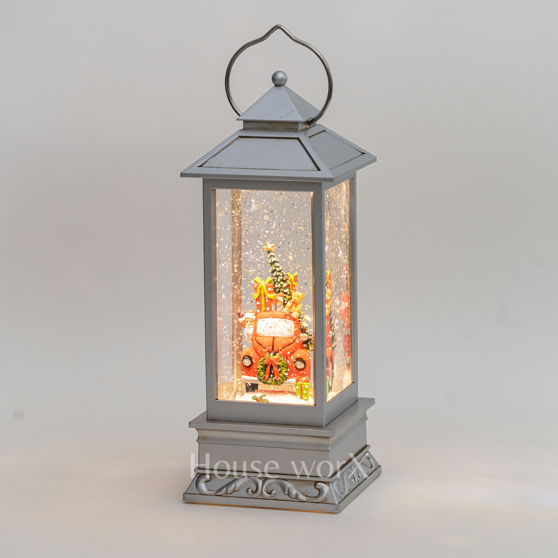 Decorative lantern with a Christmas scene inside on a gray background