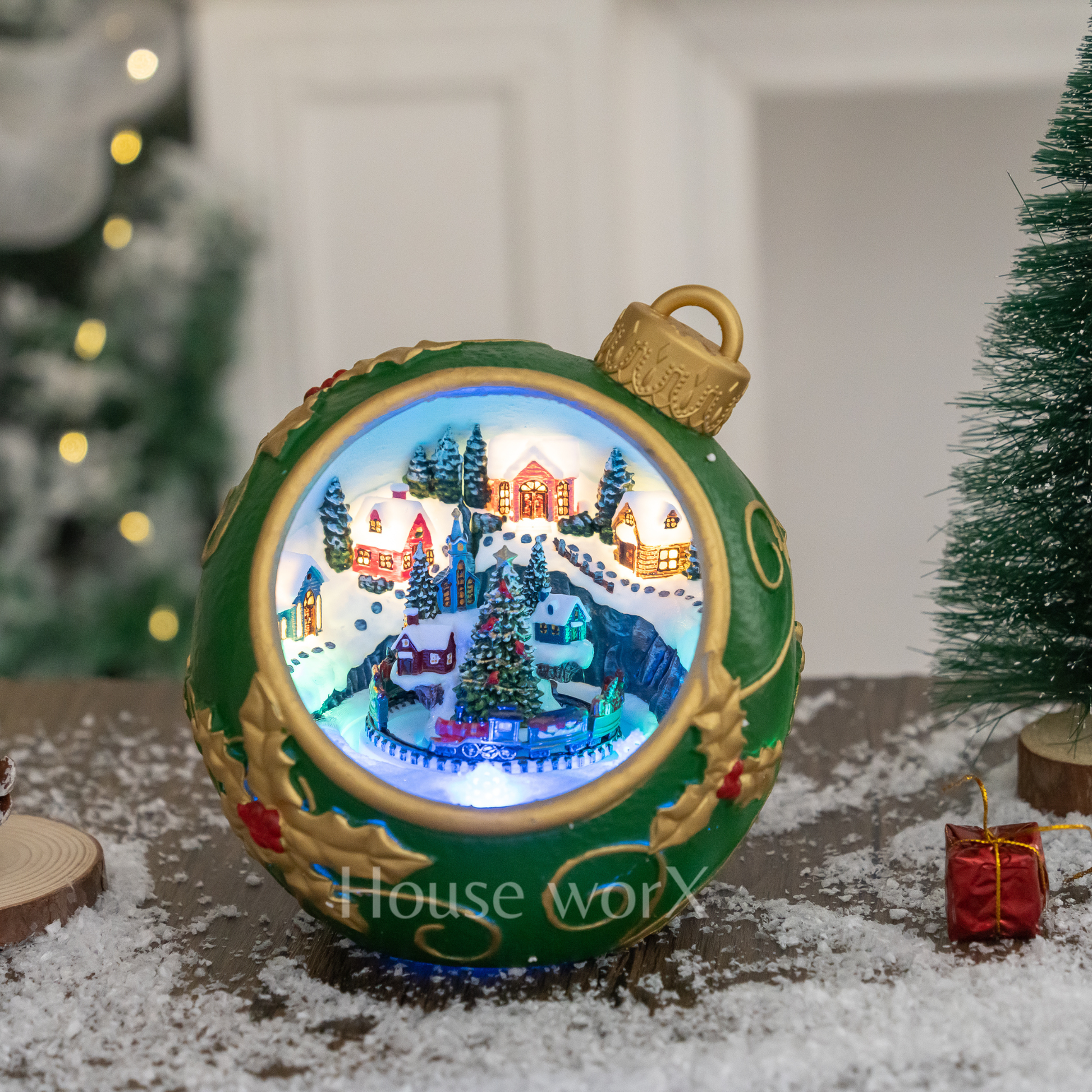 Decorative Christmas ornament with a small village scene inside, on a snowy surface.