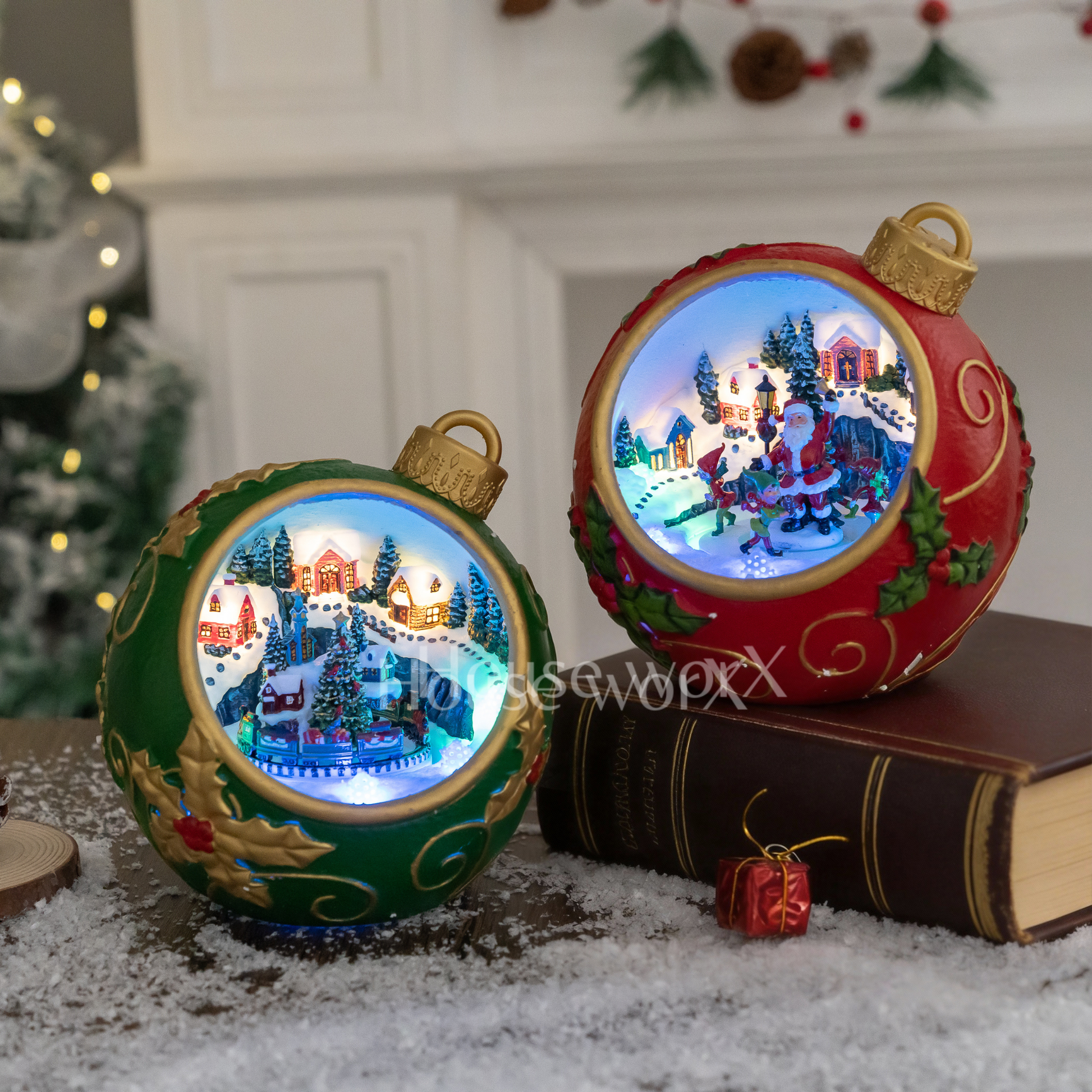 Two Christmas-themed light-up ornaments on a snowy surface with a blurred festive background.