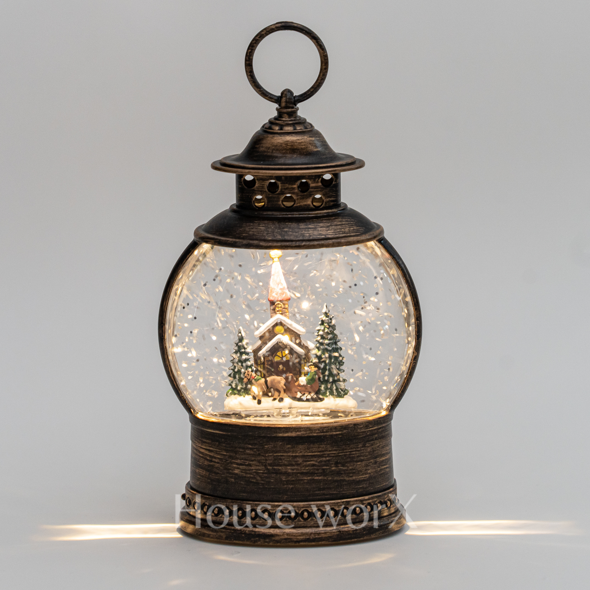 Decorative lantern with a snowy scene inside on a gray background